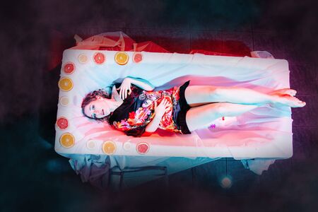 Young woman relaxing in Spa bath with slices of oranges. Welness concept.の写真素材
