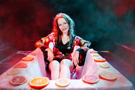 Young woman relaxing in Spa bath with slices of oranges. Welness concept.の写真素材