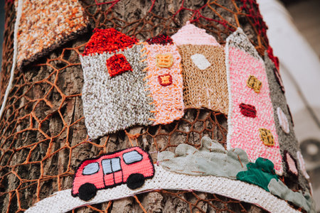 handmade decoration of knitted houses around the tree trunk over the bark