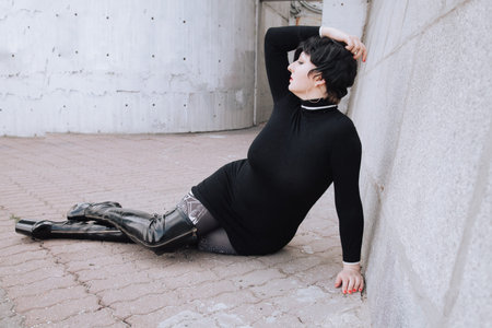 plus size short hair brunette woman in knitted sweater dress and over knee boots walking outdoor
