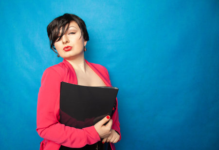 sexy Secretary in lingerie and bright pink business jacket holding a folder with documents on a blue...