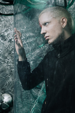 halloween make up. scary man ready for party. strange albino man with a piece of iron instead of a...