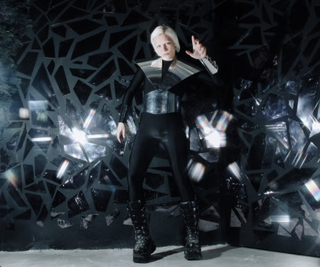 young blonde caucasian man standing in alien cosmos halloween costume and looking near the many...
