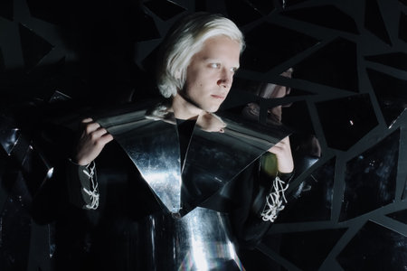 young blonde caucasian man standing in alien cosmos halloween costume and looking near the many...