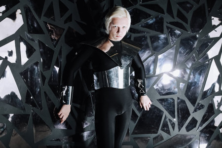 young blonde caucasian man standing in alien cosmos halloween costume and looking near the many...