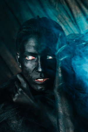 young caucasian man with white skin painted his face and hands to black color and love it. close up...