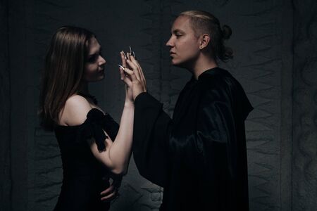 young blond guy with tanned skin embraces his slender cute girl with very white skin in the Studio at night. lovers go to Halloween party.の写真素材