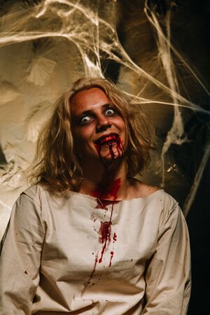 bloody stressed man. psychopath in a straitjacket with blood from his mouthの写真素材
