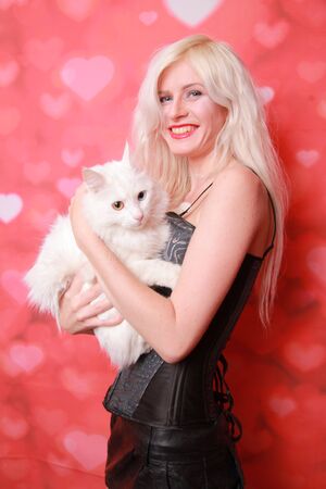 young attractive girl with lovely adult cat on studio backgroundの写真素材
