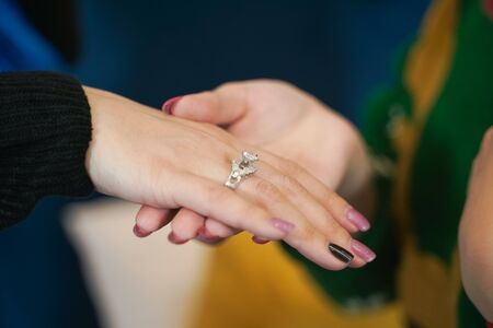pretty girl gives her friend a present wedding ring on christmas. happy woman lovely couple.の写真素材