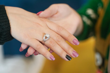 pretty girl gives her friend a present wedding ring on christmas. happy woman lovely couple.