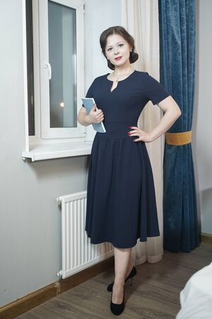 Pin up girl in blue retro dress reading a bookの写真素材