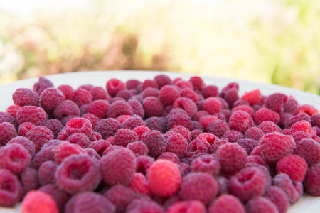 pile of raspberries in a bowl close upの写真素材