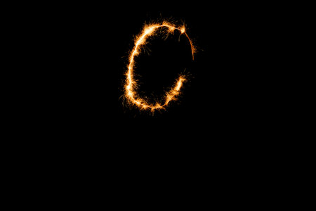 English alphabet from yellow sparkler on black backgroundの写真素材