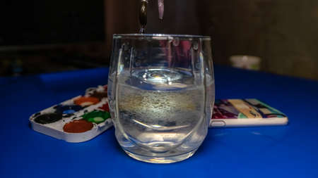 watercolor paints with brushes, on a blue table, spent paint. The tips of the brushes themselves are in focus and the rest is in focus.の写真素材