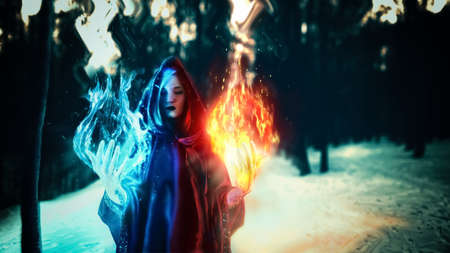 Cosplay, fantastic, artistic photo processing. A girl in a black robe, from her hands comes a fire of turquoise and dark yellow and red. Dark magic forest.の写真素材