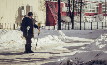 Nordic walking in Russia. Grandpa walks with sticks in winter. Sports for the elderly.のeditorial素材