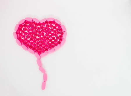 Vitamins of different types in the form of a heart, on a white isolated background. Fish oil.の写真素材