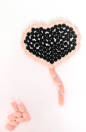 Vitamins of different types for health, laid out in the form of a heart on a white isolated...