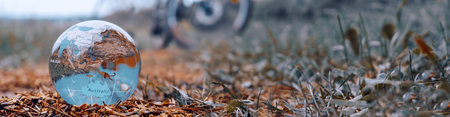 Glass ball, planet. Environment, rest, travel. The silhouette of the bike can be seen in the background. Soft selective focus.の写真素材