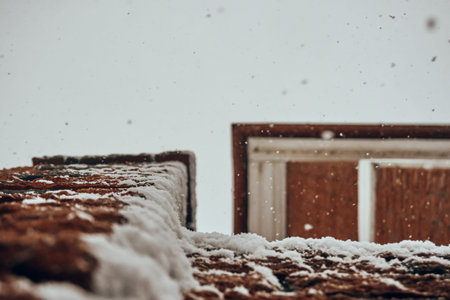 Winter, white fluffy snow lies on the streets of a brick building, a view from the bottom to the...
