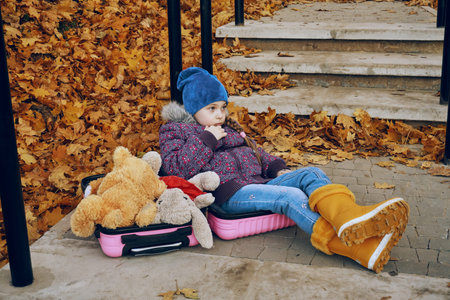 A girl child sits in a pink suitcase and thinks that on the second half of the suitcase there are...