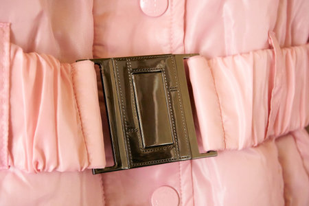 Pink jacket close-up, belt, belt with buckle, texture and pleats. Riveting.の写真素材