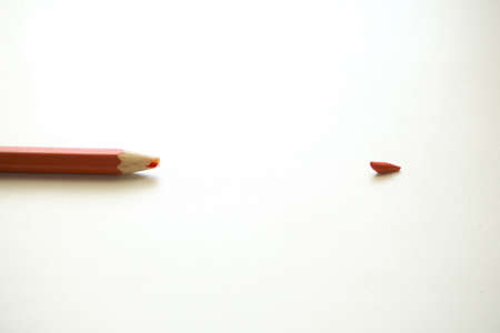 Red pencil on a white background. Broken pencil tip, concellaria, school supplies.の写真素材