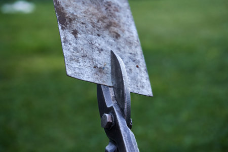 Scissors cutting a thick piece of sheet metal. Metal scissors, hand tools close-up. Selective soft...