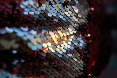 Glamorous background of multi-colored sequins, sequins. Sequins on the fabric, selective selective soft focus. Sparkles shimmer in the sun.の写真素材