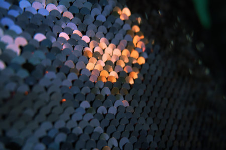 Glamorous background of multi-colored sequins, sequins. Sequins on the fabric, selective selective soft focus. Sparkles shimmer in the sun.の写真素材