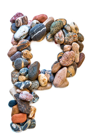 A letter of smooth stones on a white isolated background. Of the river stones lined with a letter, detailing, close-up. selective focus.の写真素材