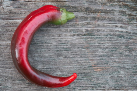 Red pepper lies on a wooden board, close-up, there is a lot of free space nearby. selective focus.