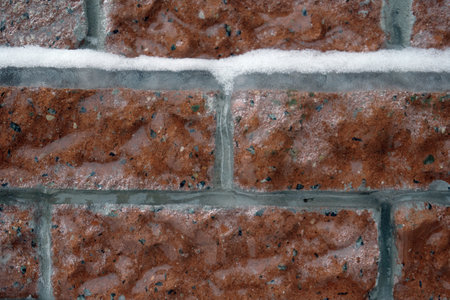 Brickwork made of red brick, covered with an ice crust, cataclysms of nature, the consequences of freezing rain. close-up.の写真素材