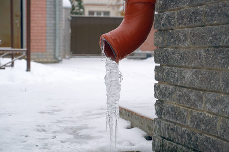 Gutter on the corner of the house, hanging icicles on the edge of the pipe. Thaw in winter,...