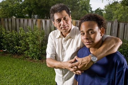 Interracial family, portrait of African teenage boy with proud Hispanic fatherの写真素材