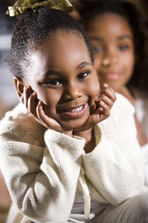 Smiling four year old African American girl with sister in backgroundの写真素材