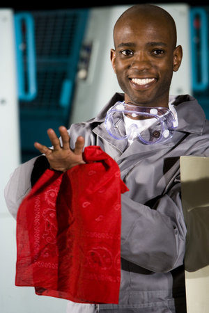 Male worker wiping hands beside a printing pressの写真素材