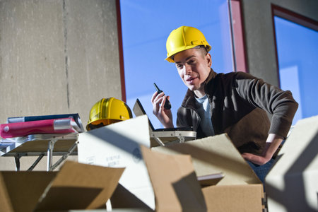 Young construction worker in unfinished room surrounded by boxes