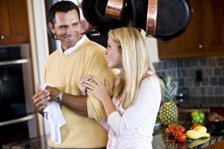 Close father and teenage daughter chatting in kitchenの写真素材