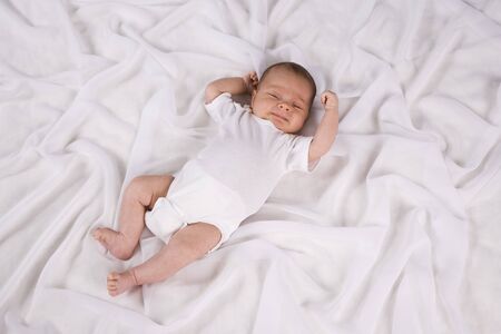 One month old newborn baby boy lying on white blanketの写真素材