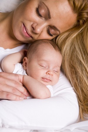Mother holding one month old baby boy in her armsの写真素材