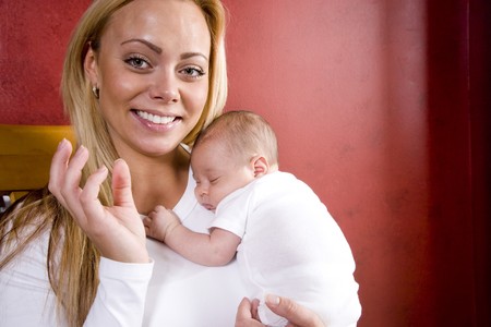 Happy young mother holding newborn baby boy in armsの写真素材