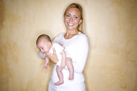 Happy young mother holding newborn baby boyの写真素材