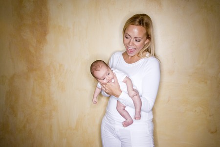 Happy young mother holding newborn baby boyの写真素材