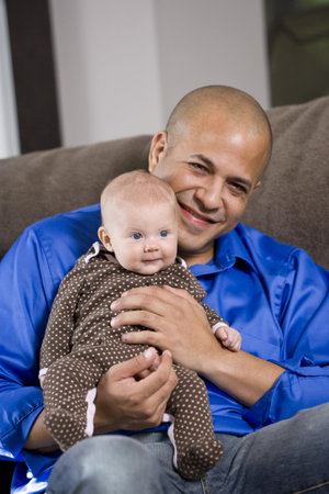 Happy dad with 3 month old baby sitting on lap