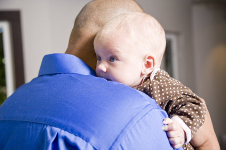 Close up of dad holding 3 month old baby on shoulder