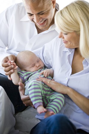 Loving parents holding 3 month old baby sound asleep in armsの写真素材