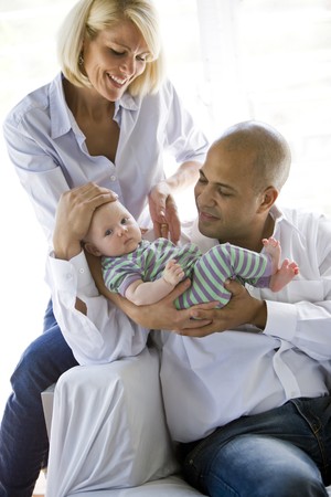 Loving parents with 3 month old baby in dad's armsの写真素材