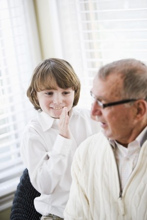 9 year old boy smiling with grandfather, focus on boyの写真素材
